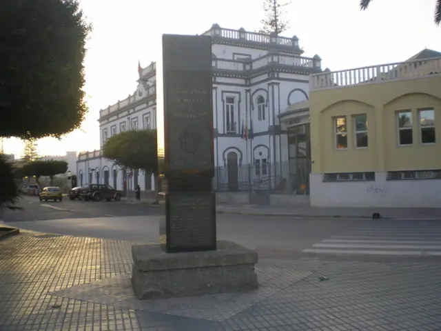 In the center of the image there is a memorial. In the background of the image there are houses....