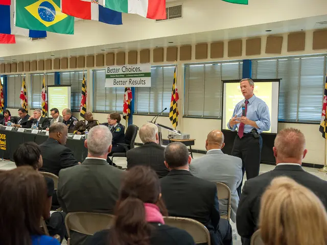 Here in this picture in the front we can see number of people sitting on chairs present on the...