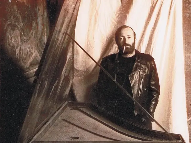 In this image a person wearing a jacket is having a cigarette in his mouth. Before him there is a...