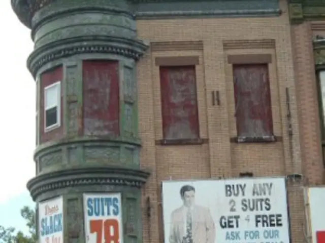 There are posters on the building in the center of the image, it seems like stalls at the bottom...