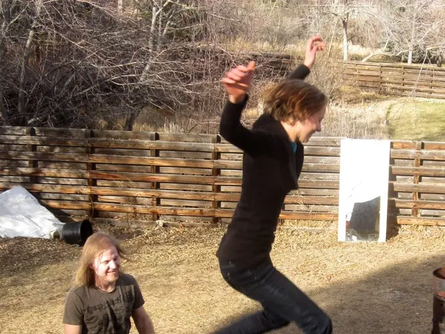 In the image there is a person in the air. At the bottom of the image there is a man standing on...