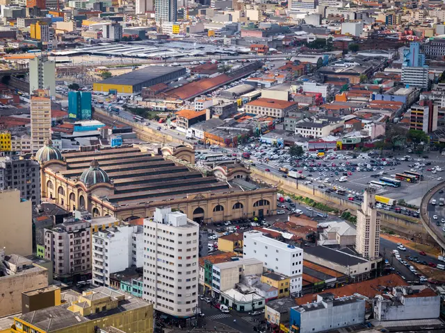 In this image, we can see so many buildings, houses, trees, vehicles, roads and bridges.