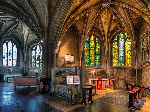 This is a picture of a building. On the right there are benches, desk, board, windows and wall. On...