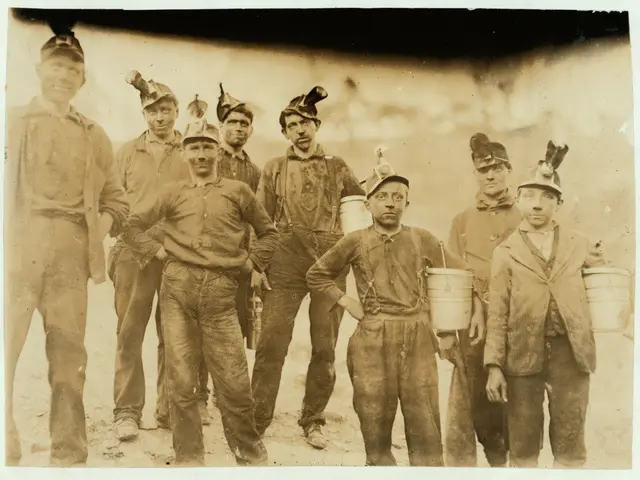 The image shows an old black and white photo of a group of men standing next to each other, each...