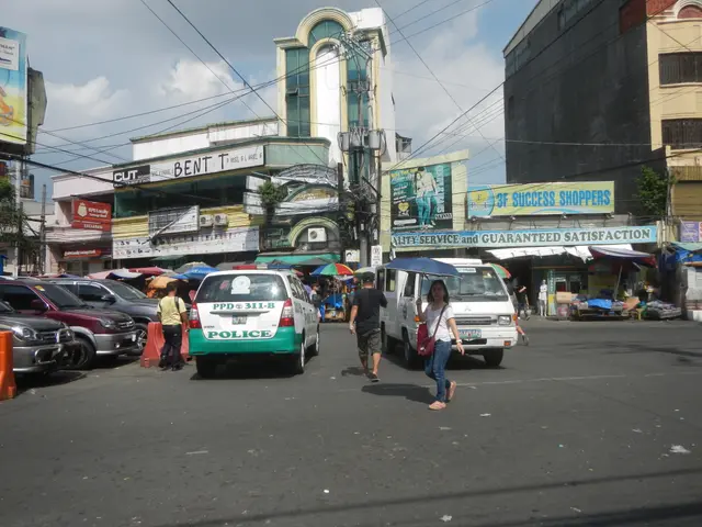 The image shows a bustling street in Manila, Philippines, with people walking on the road, vehicles...