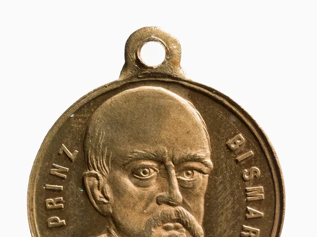 The image shows a gold medal with a portrait of a man with a mustache on it against a white...