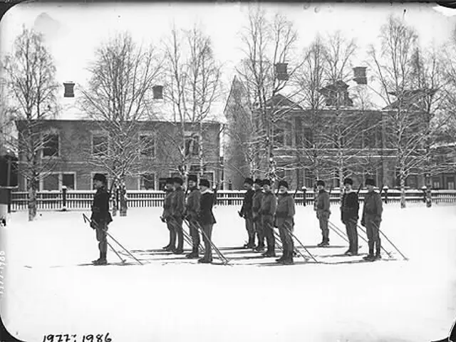 The image shows a group of men standing next to each other in the snow, wearing caps and holding...