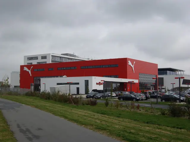 The image shows the Puma factory in Germany, with buildings, motor vehicles on the road, street...