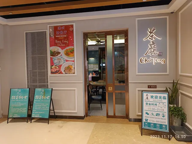 The image shows the entrance to a restaurant with Chinese writing on the wall. There are boards...