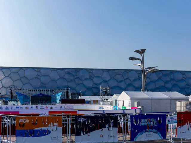 The image shows the Olympic Stadium in Sochi, Russia, with banners, railings, tents, light poles,...