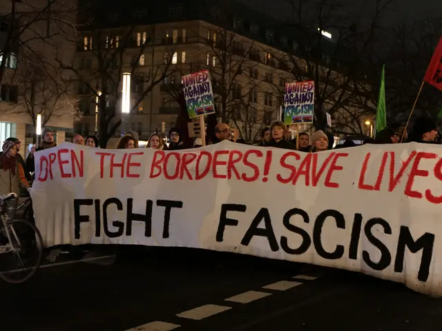 The image shows a group of people standing on the road, holding a banner that reads "Open the...