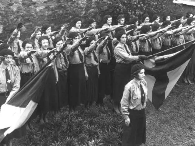 The image shows a group of women standing next to each other, holding flags in their hands, in...