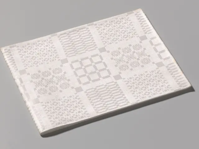 The image shows a white book with a QR code on it lying on a grey surface. The QR code is visible...