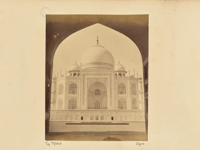 The image shows an old photo of the Taj Mahal in Agra, India, with its majestic white marble...