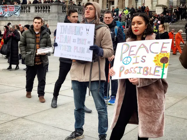 The image shows a group of people standing in front of a building, holding signs that read "Peace...