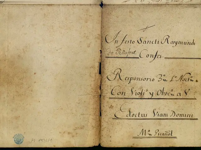 The image shows an open book with writing on it against a black background. The book appears to be...