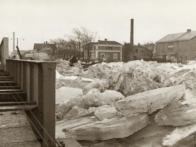 The image shows a black and white photo of a large pile of ice on the side of a road, with stairs...