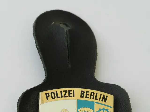 The image shows a police badge with the words "Police Berlin" on it, placed on a surface. The badge...