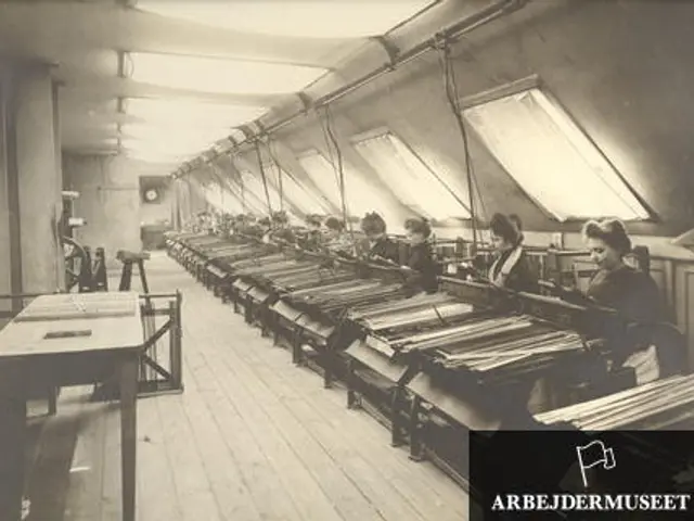 The image shows a black and white photo of a group of women working in a textile factory. They are...