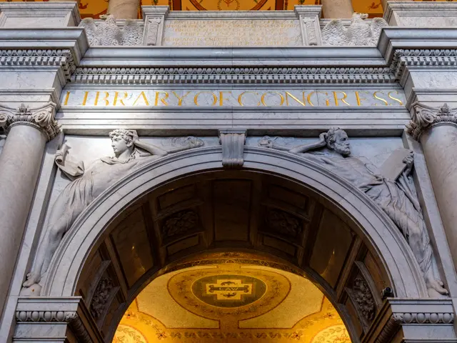 The image shows the entrance to the Library of Congress in Washington, DC. It features an arch with...