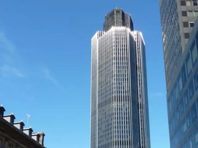 The image shows a bustling city street in London, England, with vehicles on the road, people...