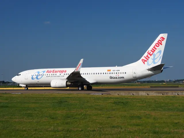 The image shows an Air Europa Airbus A330-300 on the runway surrounded by grass, a wall, a group of...