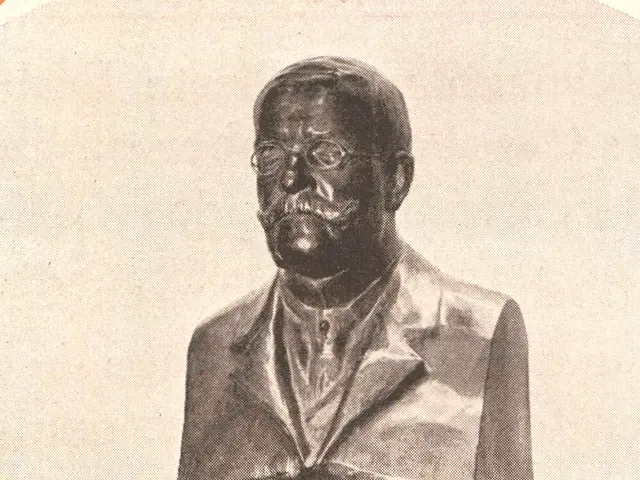 The image shows a black and white photo of a bust of a man in a suit and tie, which is believed to...