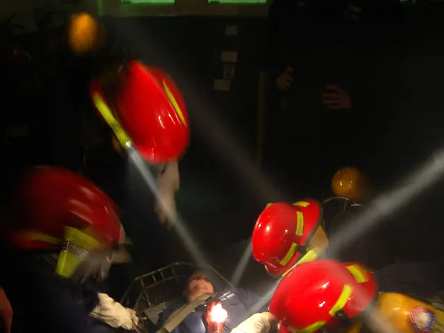 The image shows a group of people wearing helmets and gloves, with one person lying on a stretcher...