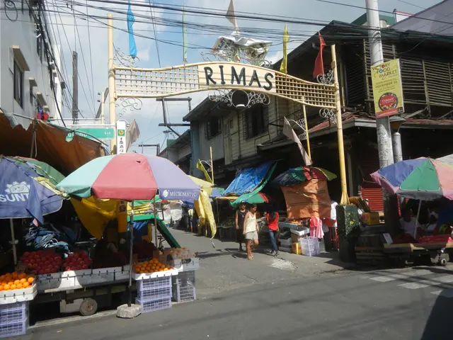 The image shows a bustling street market in Manila, Philippines, with a variety of fruits and...