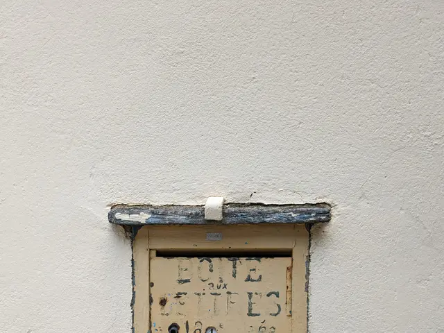 The image shows an old doorbell mounted on the side of a building. The doorbell is rectangular in...