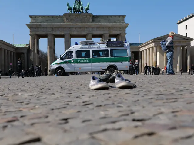 The image shows a police van parked in front of the Brandenburg Gate in Berlin, Germany. There are...