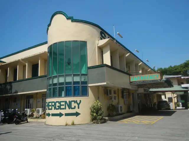 The image shows a building with a sign that reads "Emergency" on the side of it, surrounded by...