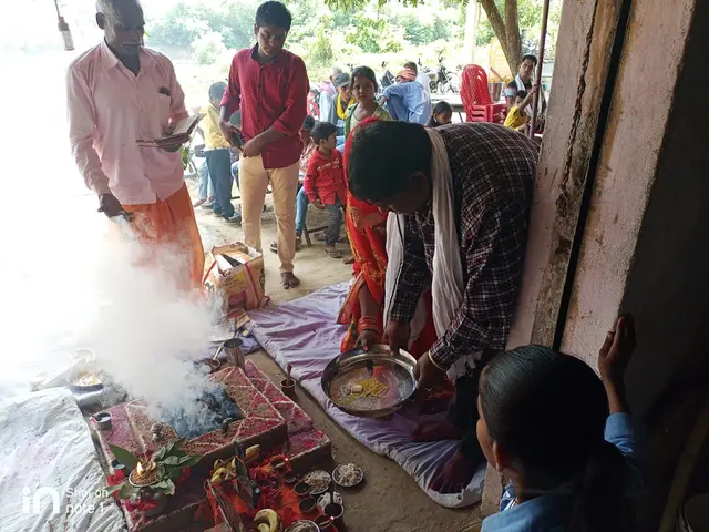 The image shows a group of people standing around a fire in a room, with a man holding a plate and...