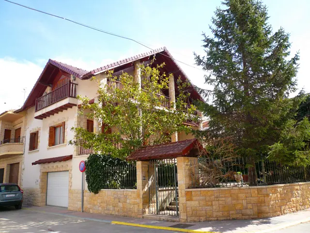 The image shows a villa with a car parked in front of it. The villa has windows, railings, pillars...