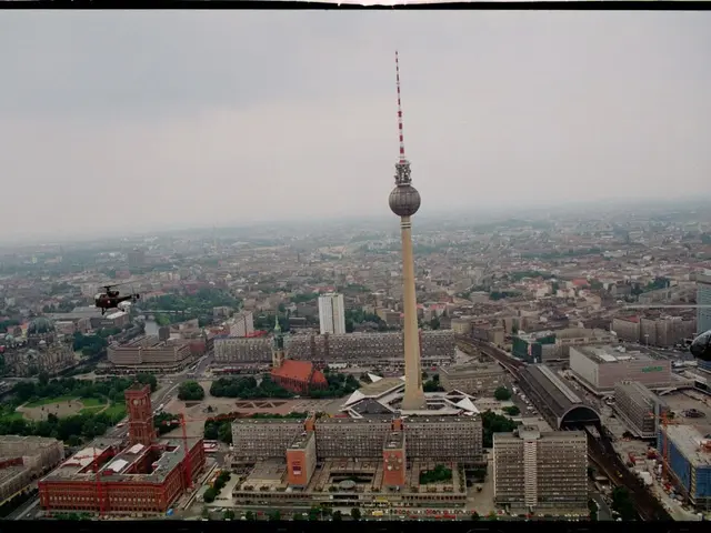 The image shows an aerial view of Berlin, Germany, with the iconic TV Tower standing tall in the...