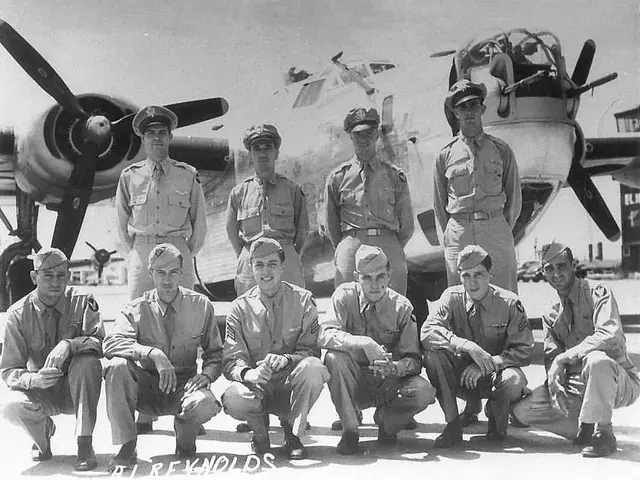 The image shows a group of men in military uniforms posing for a photo in front of an airplane. The...