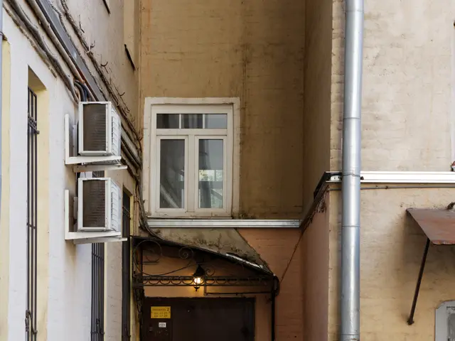 The image shows an alleyway with a building featuring a door and windows, air conditioners on the...