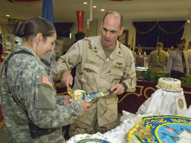 The image shows a man and woman in military uniforms cutting a cake with a knife. On the table in...