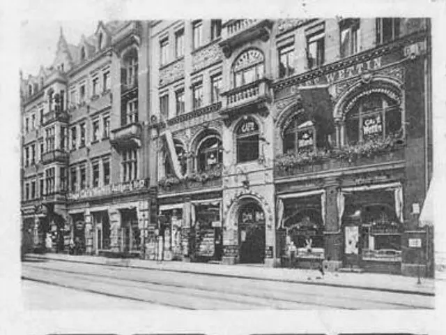 The image shows an old black and white photo of a building with a pool table in front of it. The...