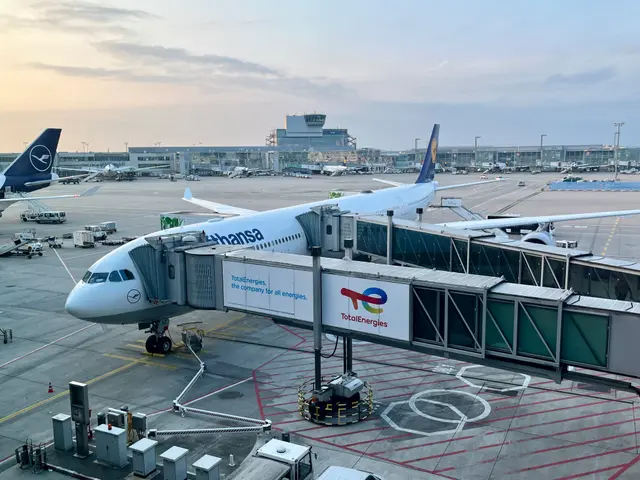 The image shows a large jetliner sitting on top of an airport tarmac surrounded by other airplanes,...