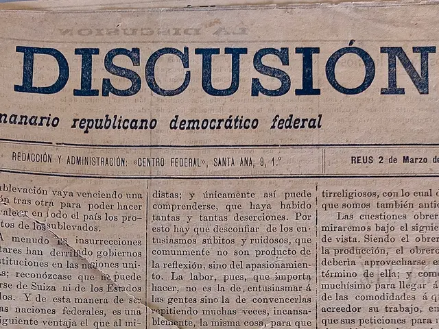 The image shows a newspaper with the word "discussion" written on it. The paper is yellowed with...