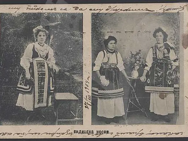 The image shows an old black and white photo of two women in traditional Russian clothing, standing...