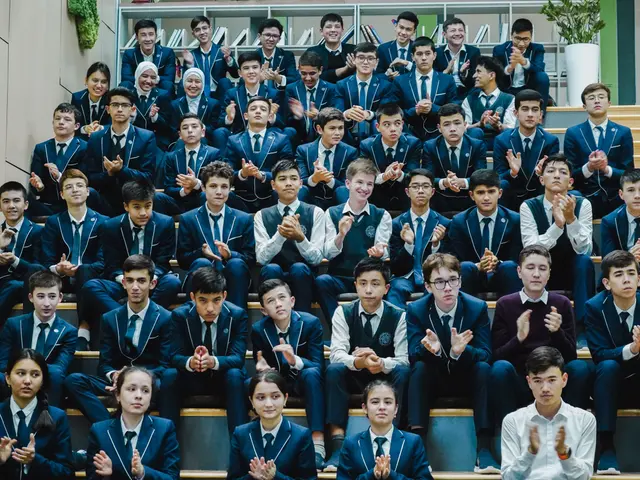 The image shows a group of young people sitting on top of a set of stairs, clapping their hands in...