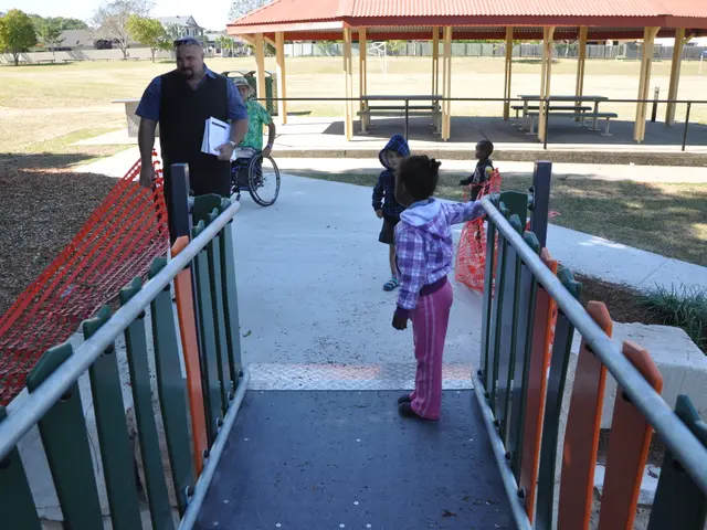 The image shows a group of people standing on top of a playground, with a man holding a book and a...