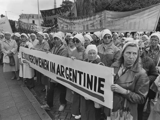The image shows a group of women standing on the ground, holding a banner that reads "Argentine...