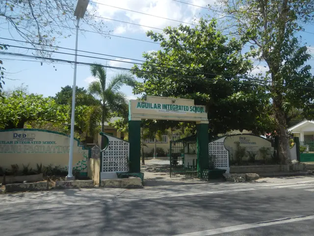 The image shows the entrance to Aguilar Integrated School in the Philippines, with an arch with...