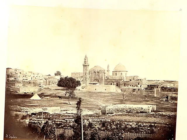 The image shows an old photo of a city with a mosque in the background, surrounded by buildings,...