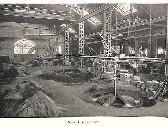 The image shows an old black and white photo of a factory with people working on a machine,...