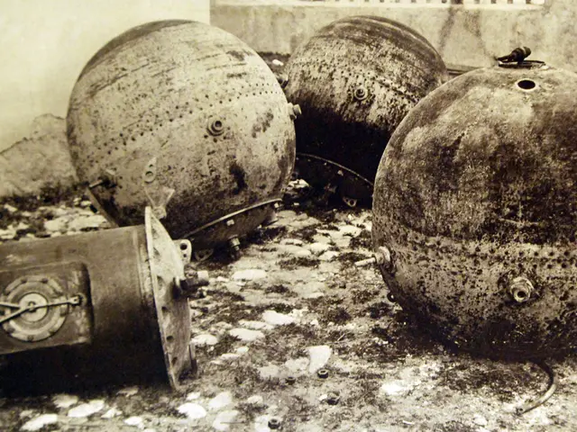 The image shows a black and white photo of three large metal bombs sitting on the ground in front...