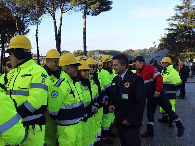 The image shows a group of people in yellow jackets and hard hats standing next to each other on a...